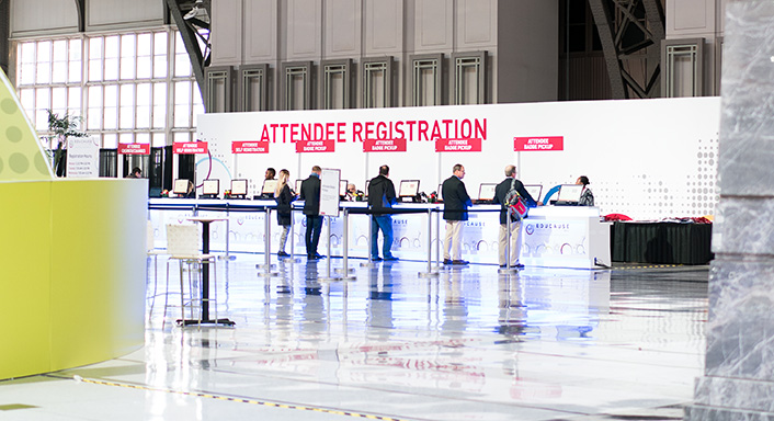 Registration desks with people in front of them registering