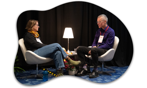 2 people sitting facing each other and talking