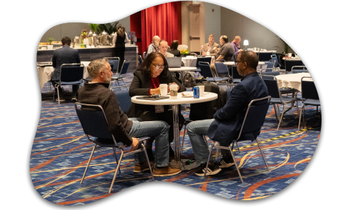 3 people talking around a small table